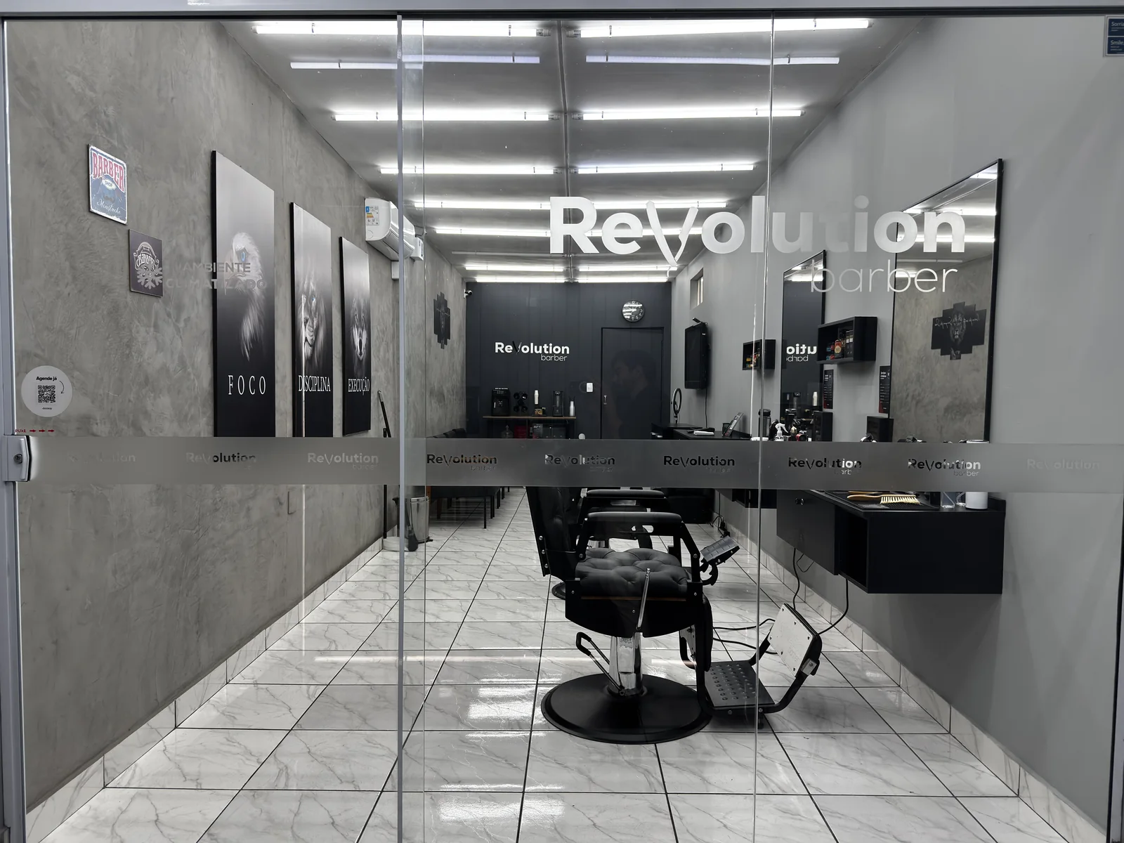 Fachada da Revolution Barber, com os quadros Foco, Disciplina e Execução